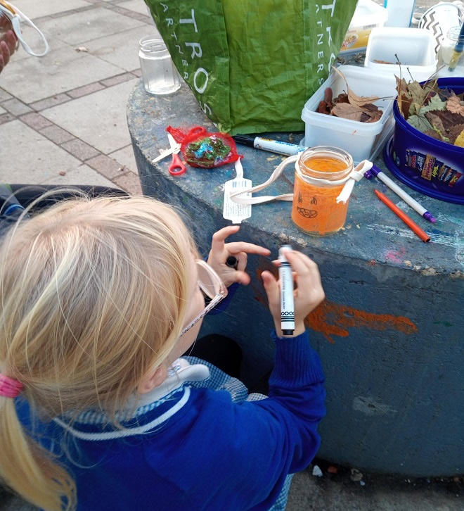 Child drawing on a glass jar